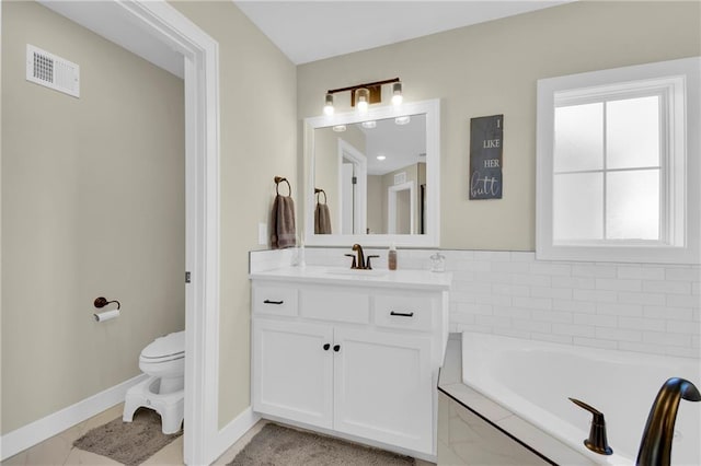 full bathroom with visible vents, baseboards, toilet, a garden tub, and vanity