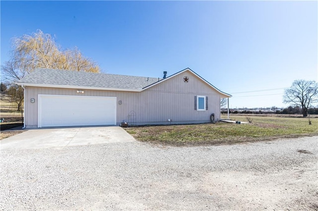 ranch-style house featuring driveway, an attached garage, and roof with shingles