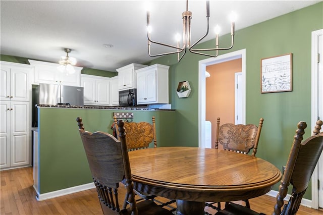 dining room with an inviting chandelier, baseboards, and light wood-type flooring