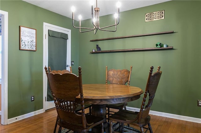 dining area featuring a notable chandelier, wood finished floors, and baseboards