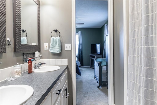 bathroom with double vanity, ensuite bathroom, and a sink