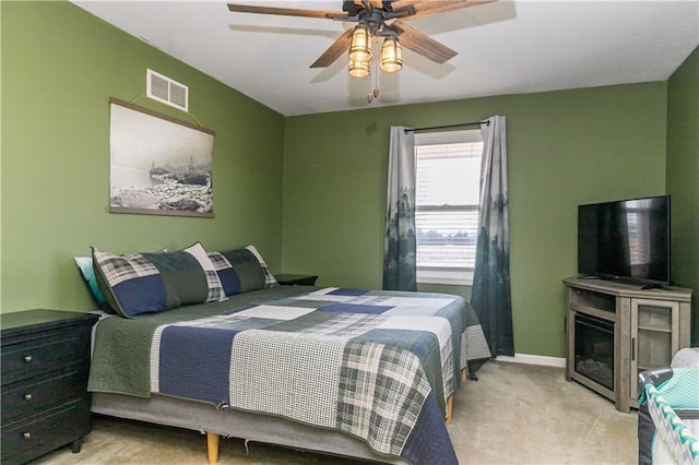 bedroom with visible vents, baseboards, light colored carpet, and ceiling fan