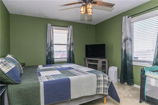 carpeted bedroom featuring baseboards and a ceiling fan