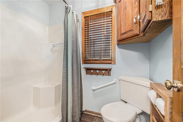 bathroom with a shower with shower curtain and toilet