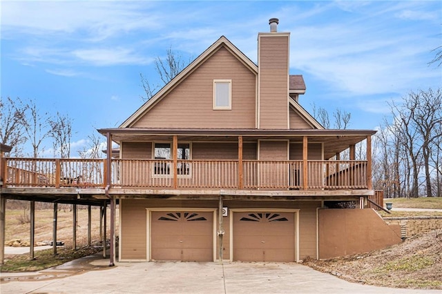 exterior space with a garage, driveway, and a chimney