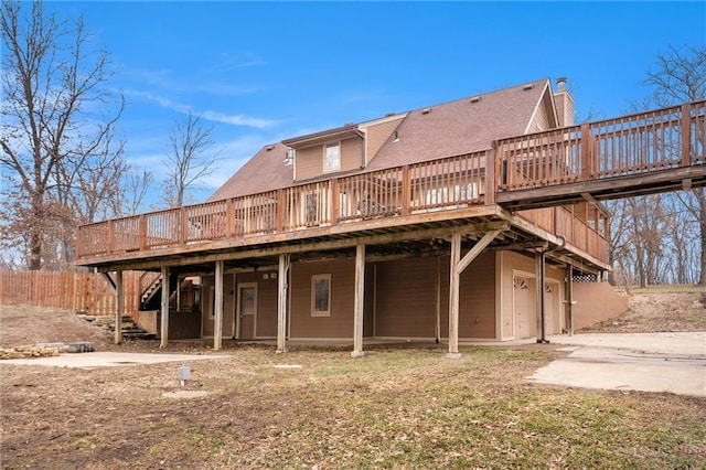 rear view of house with stairway, a deck, and driveway