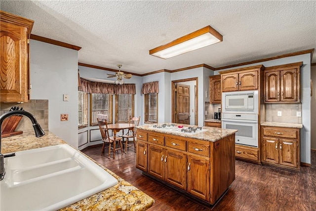 4623 Whispering Oaks Ln, Smithville, MO 64089 - kitchen with a sink, white appliances, light countertops, a textured ceiling, and a kitchen island
