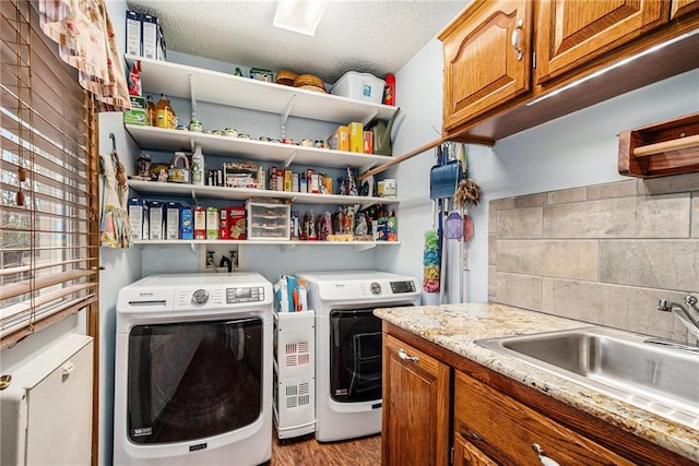 4623 Whispering Oaks Ln, Smithville, MO 64089 - laundry room featuring washer and dryer, light wood-style floors, a sink, and cabinet space