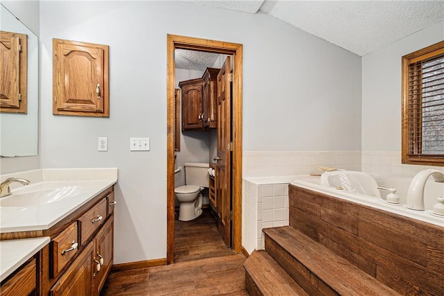 4623 Whispering Oaks Ln, Smithville, MO 64089 - bathroom featuring vanity, toilet, a textured ceiling, wood finished floors, and a garden tub