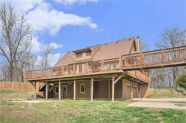 4623 Whispering Oaks Ln, Smithville, MO 64089 - back of property featuring driveway, a lawn, a wooden deck, a garage, and fence