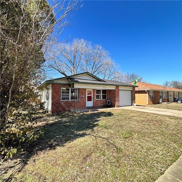 view of front of home featuring a garage, concrete driveway, brick siding, and a front lawn