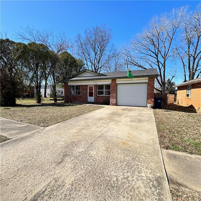 single story home featuring a garage, brick siding, driveway, and fence