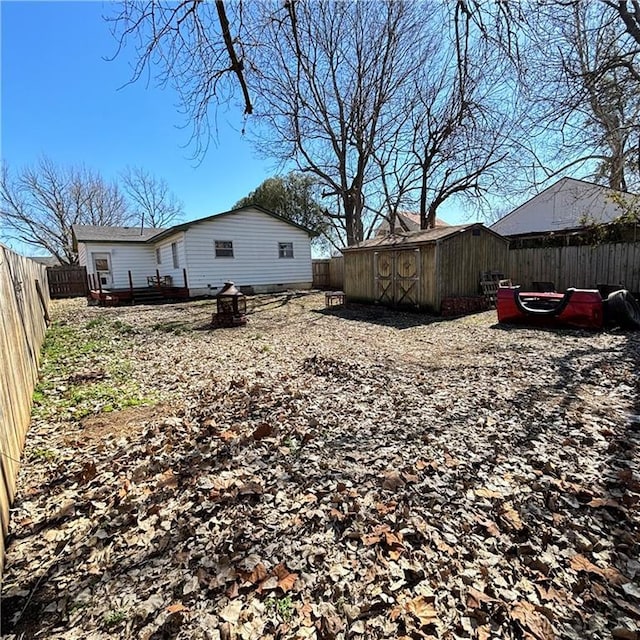 view of yard with an outbuilding, a fenced backyard, and a shed