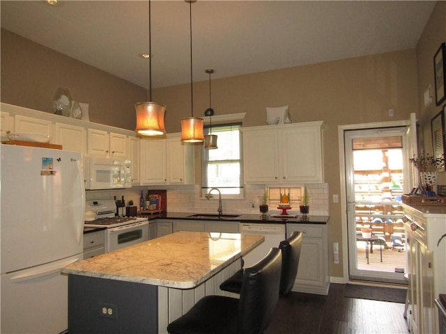 kitchen featuring a sink, white appliances, a kitchen island, decorative backsplash, and white cabinetry