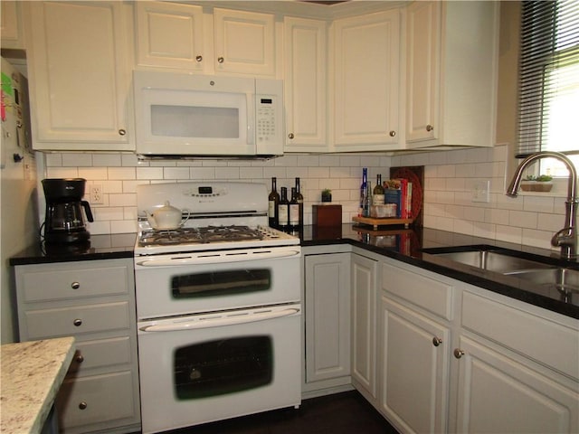 kitchen featuring decorative backsplash, white cabinetry, a sink, and white appliances