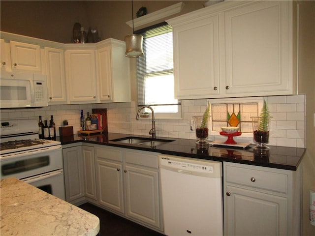 kitchen with a sink, hanging light fixtures, white appliances, backsplash, and white cabinetry