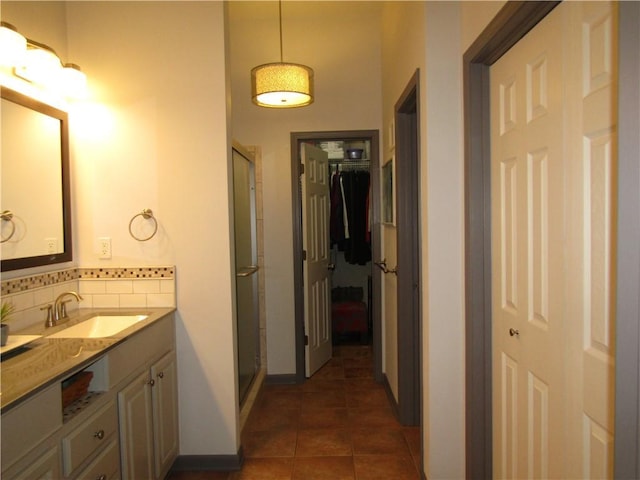 bathroom with tasteful backsplash, a shower stall, tile patterned floors, and vanity