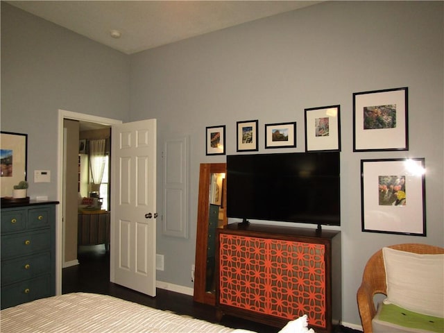 bedroom with dark wood finished floors and baseboards