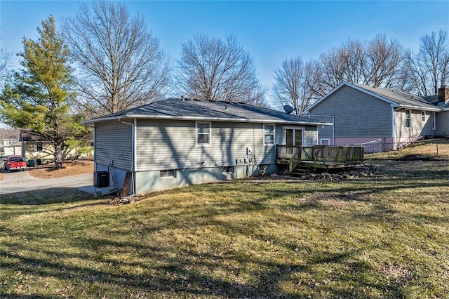 rear view of house featuring a deck, a yard, fence, and central AC