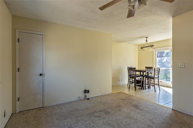 tiled dining space with carpet flooring, a ceiling fan, baseboards, and a textured ceiling