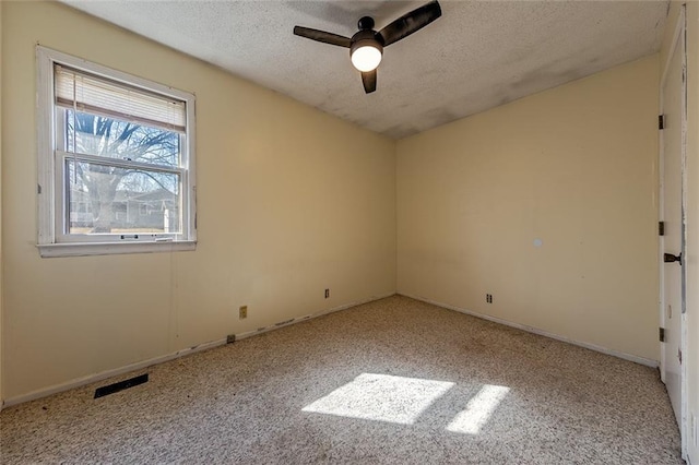 carpeted empty room with a ceiling fan, baseboards, visible vents, lofted ceiling, and a textured ceiling