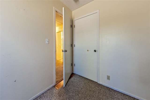 unfurnished bedroom featuring a textured ceiling and baseboards