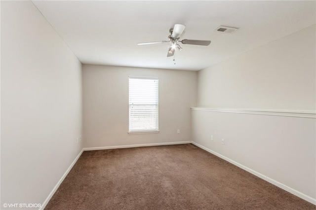 empty room with baseboards, carpet, visible vents, and ceiling fan