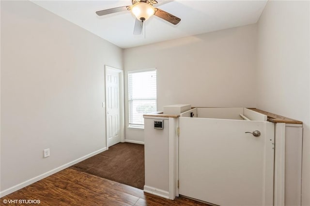 laundry room with baseboards, dark wood-type flooring, and a ceiling fan