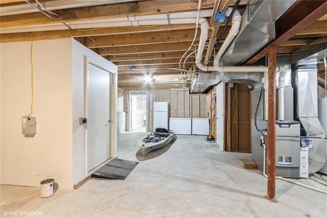 below grade area with heating unit and freestanding refrigerator
