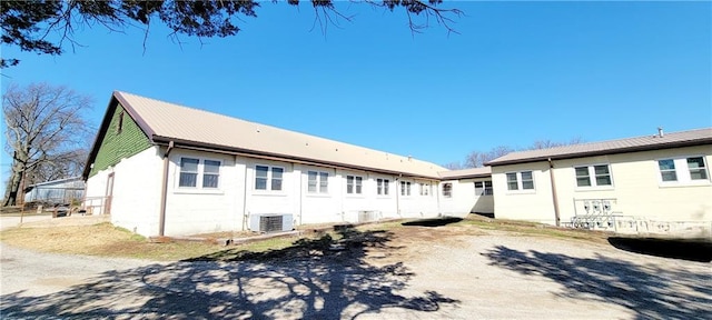 rear view of house with metal roof and central AC
