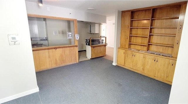 kitchen featuring dark colored carpet and light brown cabinetry