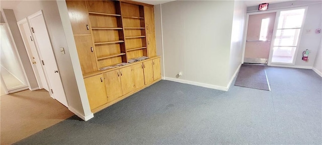 corridor with dark carpet and baseboards