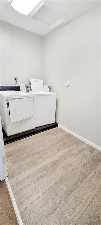shared laundry area featuring attic access, baseboards, washer and clothes dryer, and wood finished floors