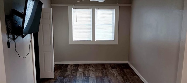 empty room with dark wood-style floors and baseboards