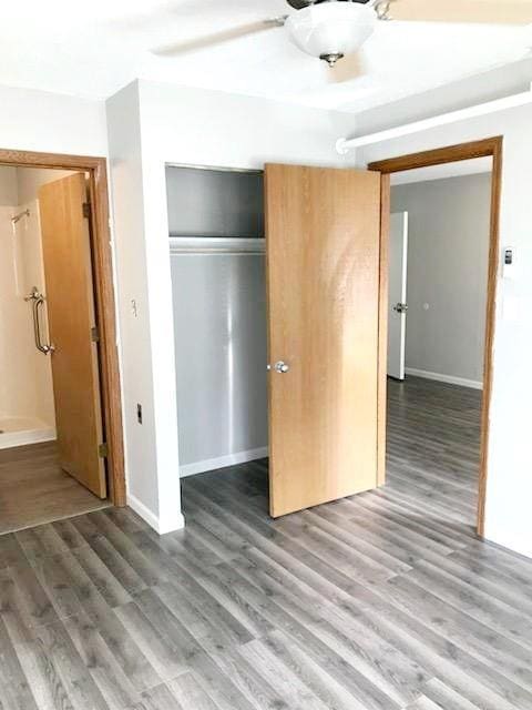 unfurnished bedroom featuring a closet, wood finished floors, and baseboards