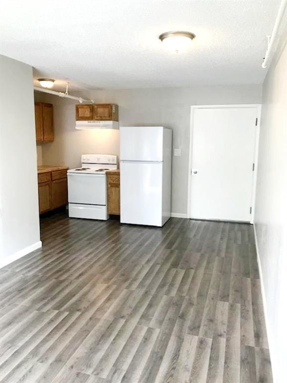 kitchen with white appliances, dark wood-style flooring, brown cabinets, and under cabinet range hood