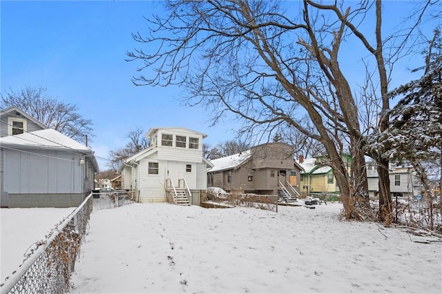 snow covered house with a residential view and entry steps