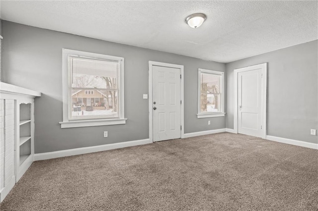 interior space with baseboards, a wealth of natural light, and a textured ceiling