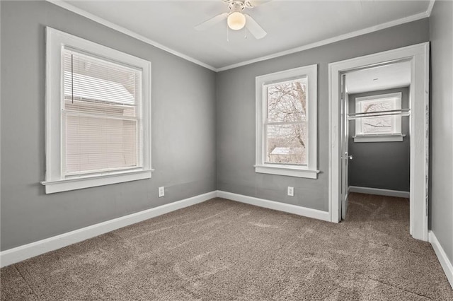 unfurnished bedroom featuring carpet flooring, ceiling fan, baseboards, and ornamental molding