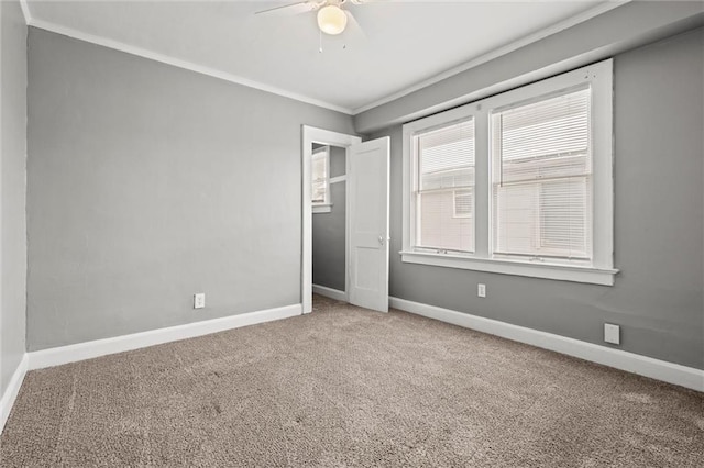 spare room featuring baseboards, a ceiling fan, carpet flooring, and crown molding