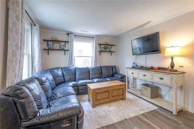 living area with ornamental molding and wood finished floors