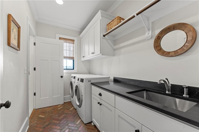 clothes washing area featuring ornamental molding, a sink, washing machine and dryer, cabinet space, and brick floor