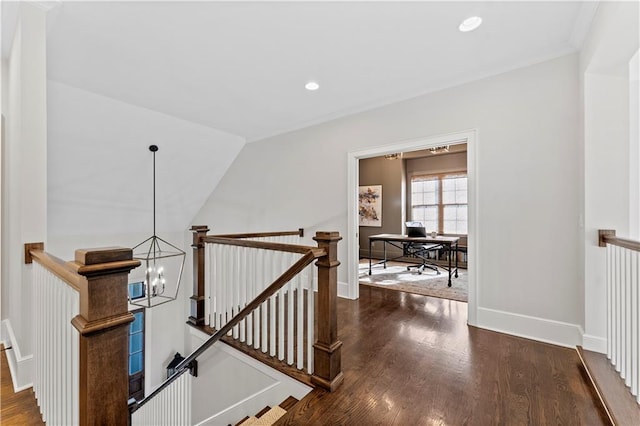 hall featuring wood finished floors, baseboards, an inviting chandelier, recessed lighting, and an upstairs landing