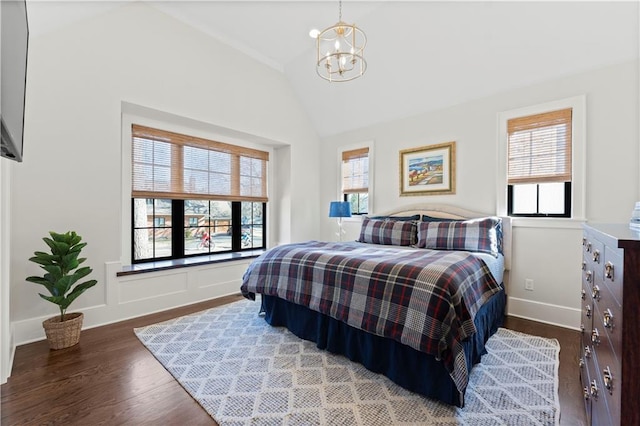 bedroom with baseboards, wood finished floors, an inviting chandelier, and vaulted ceiling