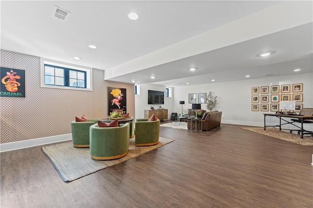 interior space featuring dark wood-style floors, baseboards, visible vents, wallpapered walls, and an accent wall