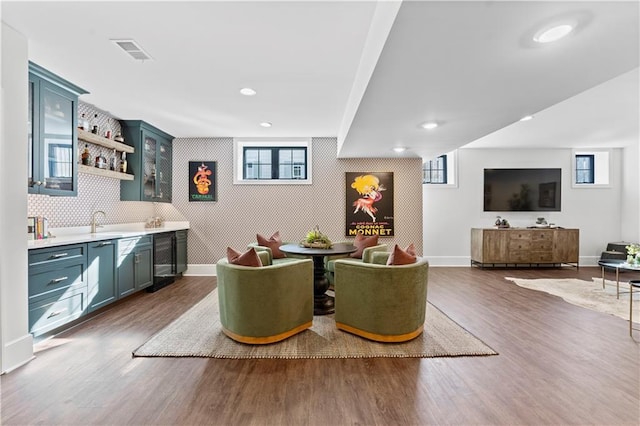 interior space featuring wet bar, dark wood-type flooring, baseboards, and visible vents