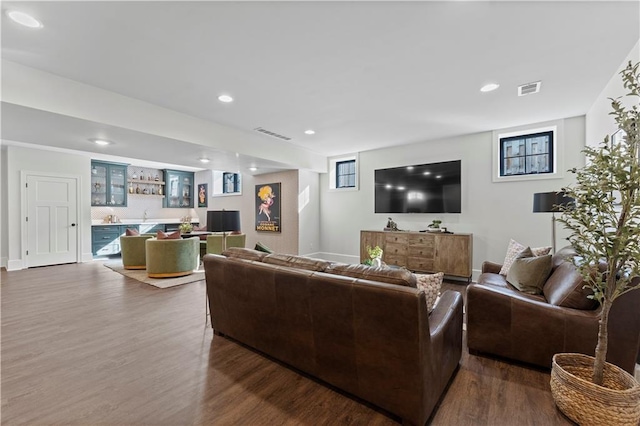 living room with recessed lighting, visible vents, indoor bar, and dark wood-style flooring