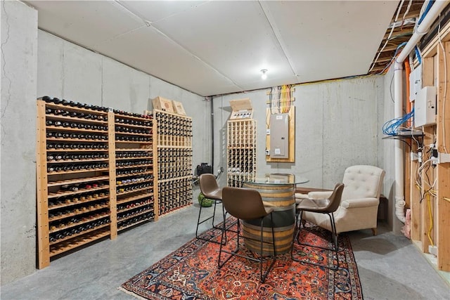 wine room with electric panel and concrete floors