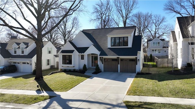 view of front of property with driveway, an attached garage, a front lawn, and fence