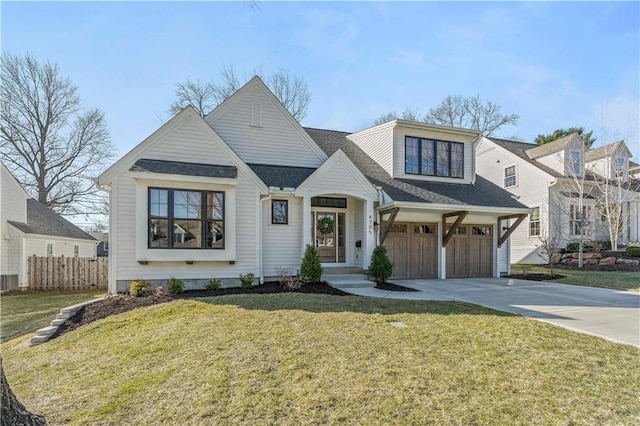 view of front facade featuring a front lawn, fence, roof with shingles, concrete driveway, and an attached garage